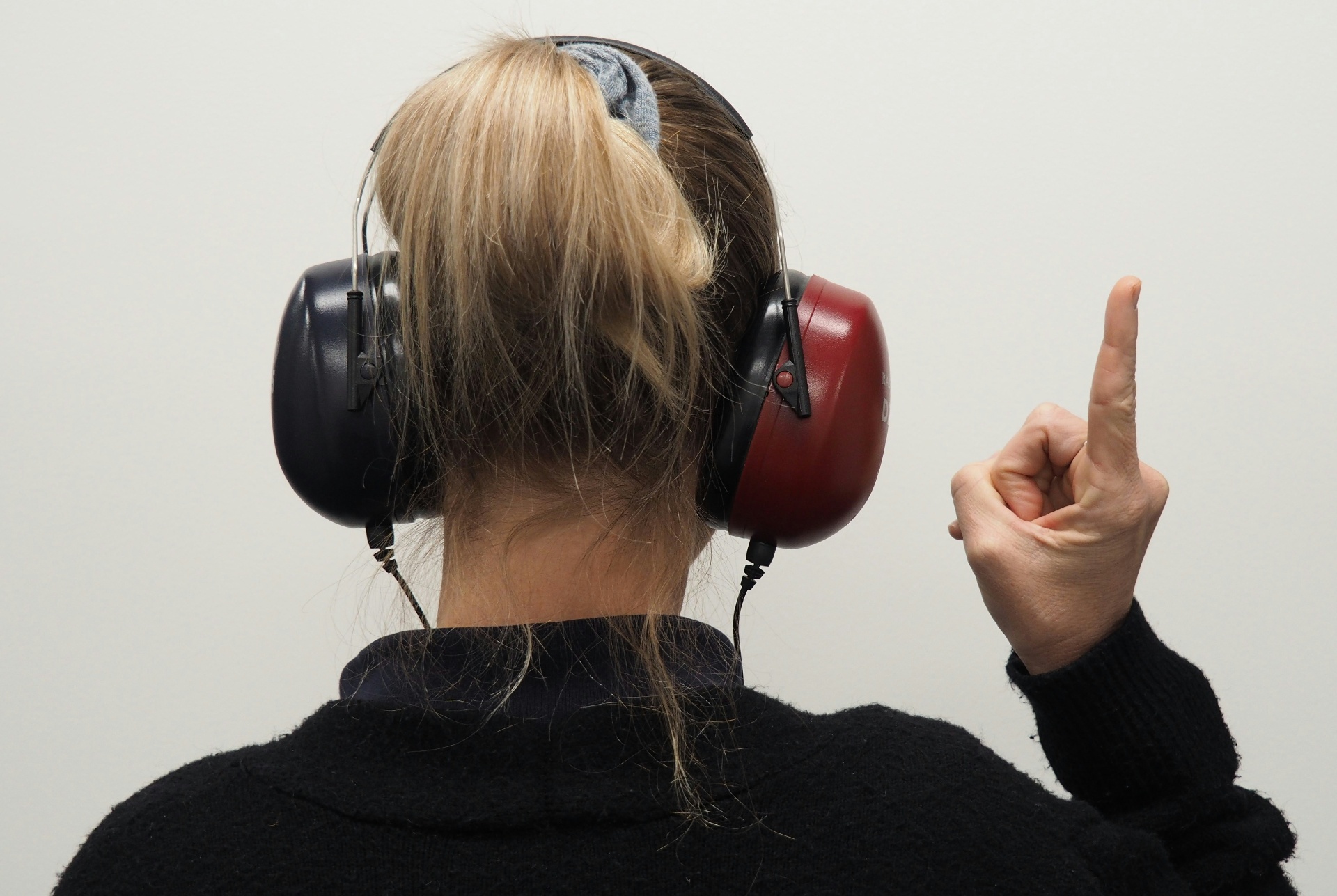 A patient wearing audiometric headphones while an audiologist carries out a hearing assessment